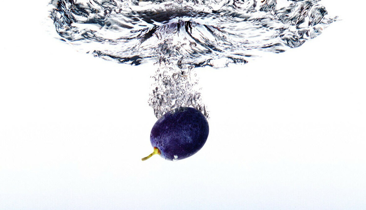 Marketing image for Ciroc Vodka displaying a blue grape splashing into a clear liquid.